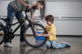 Father and little son checking tire of bicycle