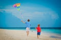 Father and little son flying kite on beach