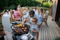 Father with little son grilling outside during family summer garden party. Royalty Free Stock Photo