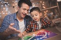 Father and little son are playing board game at night at home. Royalty Free Stock Photo