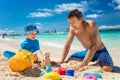 Father and little son playing with sand