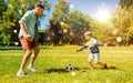 father with little son playing soccer at park Royalty Free Stock Photo