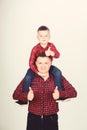 Father little son red shirts family look outfit. Best friends forever. Dad piggybacking adorable child. Having fun Royalty Free Stock Photo