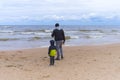 Father and little son walk together and enjoy view of lake