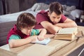 Father looking at concentrated son doing homework Royalty Free Stock Photo