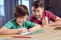 Father looking at concentrated son doing homework Royalty Free Stock Photo