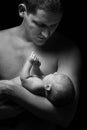 Father looking at newborn baby lying down on hand