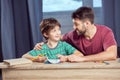 Father looking at son while doing homework Royalty Free Stock Photo