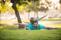 Father lying on grass, with excited happy little child son on shoulder. Carefree two man generations family having fun. Royalty Free Stock Photo