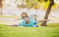 Father lying on grass, with excited happy little child son on shoulder. Carefree two man generations family having fun Royalty Free Stock Photo