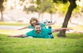 Father lying on grass, with excited happy little child son on shoulder. Carefree two man generations family having fun Royalty Free Stock Photo