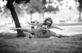 Father lying on grass, with excited happy little child son on shoulder. Carefree two man generations family having fun Royalty Free Stock Photo