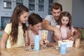 Father Making Ice Cream Sundaes With Children At Home