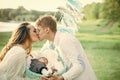 Father man kiss mother woman with baby child in crib