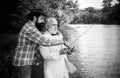 Father and mature son fisherman fishing with a fishing rod on river. Portrait of senior businessman fishing in white