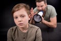 Father with megaphone screaming at scared little son Royalty Free Stock Photo