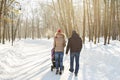 Father and mother with baby carriage in winter forest Royalty Free Stock Photo