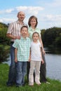 Father, mother, boy and girl is staying near pond Royalty Free Stock Photo