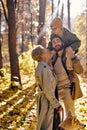 Father, mother and child boy walking with dog in warm sunny day in forest at autumn Royalty Free Stock Photo