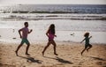 Father, mother and child jogging on the beach. Concept healthy family lifestyle. Summer people vacation at sea. Sport Royalty Free Stock Photo