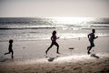 Father, mother and child run on the beach. Concept healthy family lifestyle. Summer people running, parents and child on Royalty Free Stock Photo