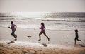 Father, mother and child run on the beach. Concept healthy family lifestyle. Summer people running, parents and child on Royalty Free Stock Photo