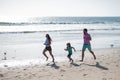 Father, mother and child run on the beach. Concept healthy family lifestyle. Summer people vacation at sea. Healthy Royalty Free Stock Photo