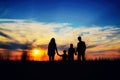 Father, mother, and children hold hands on a sunset background. Royalty Free Stock Photo