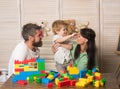 Father, mother and cute kid on light wooden background. Royalty Free Stock Photo