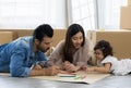 Father Mother and daughter drawing and coloring with colored pencils lying down on the floor. Happy family moment in the house.Art Royalty Free Stock Photo