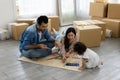 Father Mother and daughter drawing and painting coloring with watercolor lying down on the floor. Happy family moment in the house Royalty Free Stock Photo