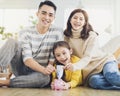 Father, mother and daughter holding a piggy bank and money at home. Family and saving for future concept Royalty Free Stock Photo