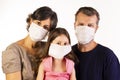 Father, mother and daughter wearing protective masks on white background