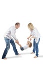 Father and mother hold daughter for hands and feet