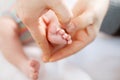 Father or mother holding foot of newborn baby Royalty Free Stock Photo