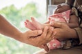 Father and mother holding one-month-old daughter's tiny feet in her palms with love and protect Royalty Free Stock Photo