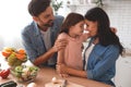 Father and mother hugging daughter on the kitchen, portrait