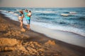 Father, mother and kids walking along the beach, near the ocean, happy lifestyle family concept Royalty Free Stock Photo