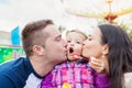 Father, mother kissing their daughter blowing bubbles, amusement Royalty Free Stock Photo