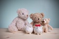 Father, mother, and little bears with two white piggy banks on an old wooden table with copy space. Planning savings money to buy Royalty Free Stock Photo