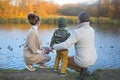 Father, mother and little son feeding ducks Royalty Free Stock Photo