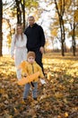 Father, mother and little son play together in autumn park or forest. Child launching orange toy airplane. Family Royalty Free Stock Photo