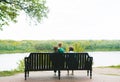 Father, mother and little son sitting on a bench in spring park, looking the lake. Back view Royalty Free Stock Photo