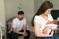 Father and mother with a newborn son sitting in the room