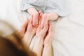 Father and mother, parents, holding feet of the their baby in their hands Royalty Free Stock Photo