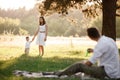 Father, mother and son blow soap bubbles in the park together on a sunny summer day. happy family having fun outdoor Royalty Free Stock Photo