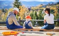 Father, mother and son building wooden frame house. Royalty Free Stock Photo