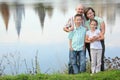 Father, mother, son and daughter staying near pond Royalty Free Stock Photo