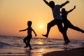 Father mother and son playing on the beach at the sunset time. Royalty Free Stock Photo