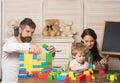 Father, mother and son in playroom on light wooden background. Royalty Free Stock Photo
